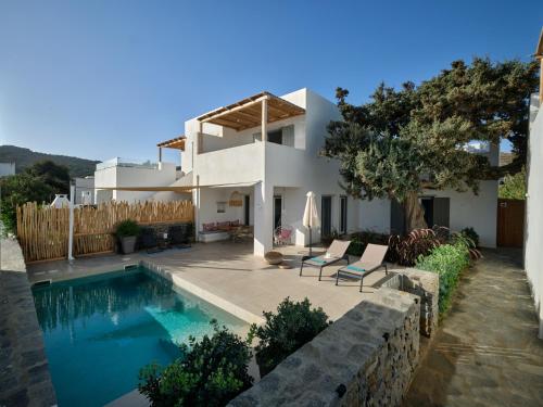 a villa with a swimming pool and a house at Private Luxury Scarlet beachfront villa, Molos, Paros in Molos Parou