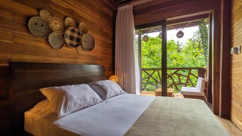 Yaku Hostel في Playa Mendiguaca: غرفة نوم بسرير كبير ونافذة
