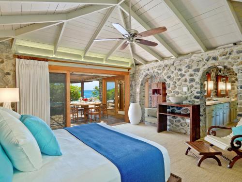 a bedroom with a large bed with a ceiling fan at Petit St. Vincent Resort in Petite Martinique
