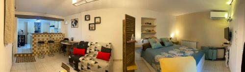 a bedroom with a bed and a living room with a couch at Le Refuge in Montmeyan