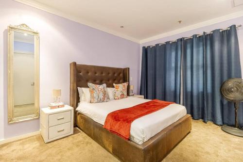 a bedroom with a large bed and a mirror at 2 Bedroom Oasis in MRP in Cape Town