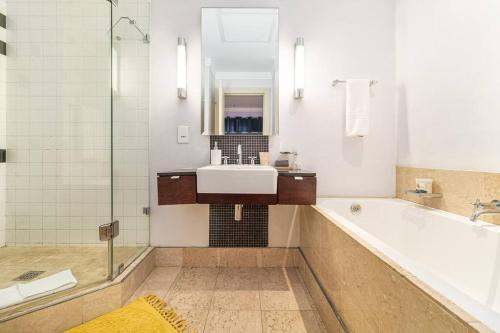 uma casa de banho com uma banheira, um lavatório e um chuveiro em 2 Bedroom Oasis in MRP em Cidade do Cabo