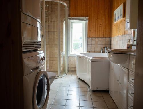a bathroom with a washing machine and a sink at Bergmannsgata 3 in Røros