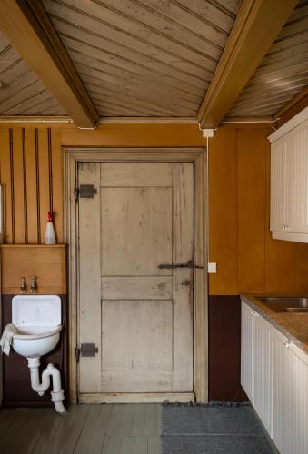 a bathroom with a wooden door and a toilet at Bergmannsgata 3 in Røros