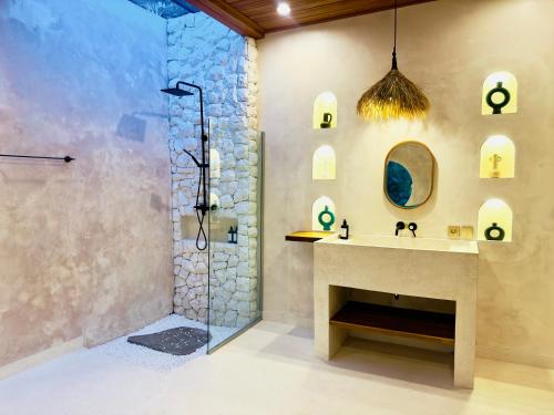bagno con doccia, lavandino e specchio di Nick Villa ad Ubud