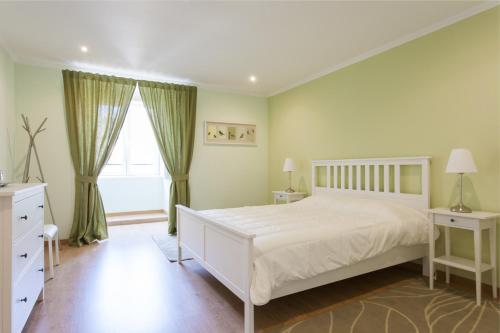 ein Schlafzimmer mit einem weißen Bett und einem Fenster in der Unterkunft FLH Bairro Alto Artistic with View in Lissabon