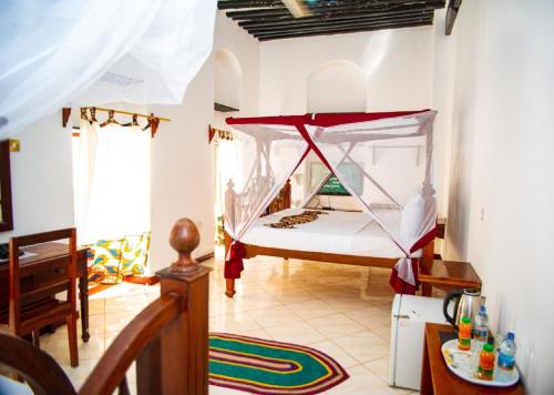 a bedroom with a bed with a mosquito net at La Neisha Hotel Zanzibar in Stone Town