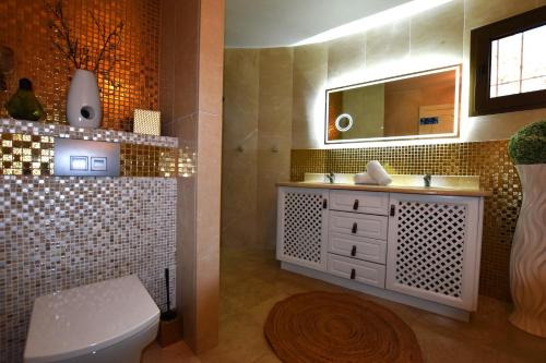 a bathroom with a toilet and a sink and a mirror at Fustera Villa El Salvador in Benissa