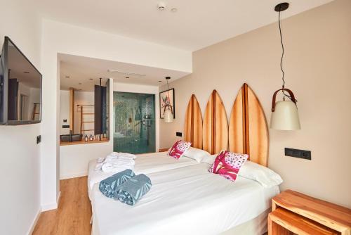 two beds in a room with surfboards on the wall at Hotel Florida Magaluf - Adults Only in Magaluf