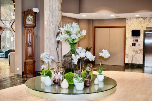 a glass table with a vase filled with white flowers at Bedford Hotel & Congress Centre in Brussels