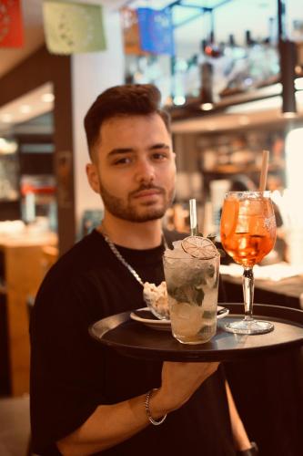 a man is holding a tray with a drink at Bedford Hotel Brussels in Brussels
