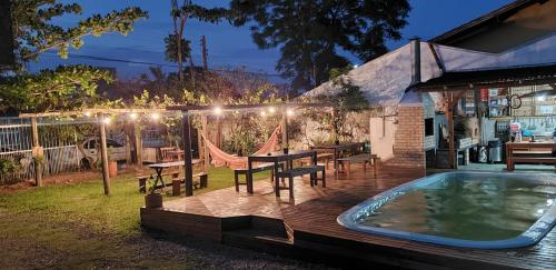 a patio with a table and a swimming pool at Hostel Bombinhas in Bombinhas