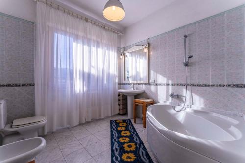 a bathroom with a tub and a toilet and a sink at Casa Vacanza Mais in Camaiore