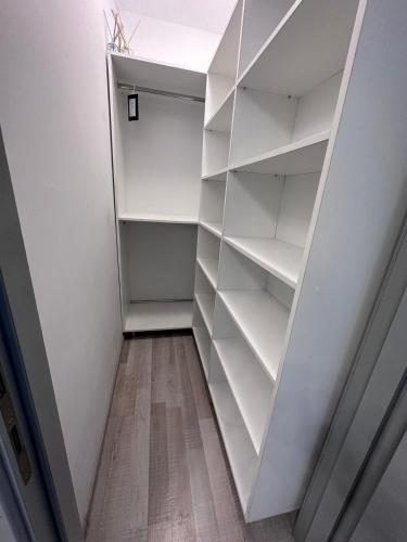 a walk in closet with white shelves at Coresi Mall Relax apartment in Braşov