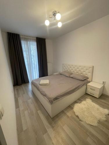a bedroom with a bed and a window and a rug at Coresi Mall Relax apartment in Braşov