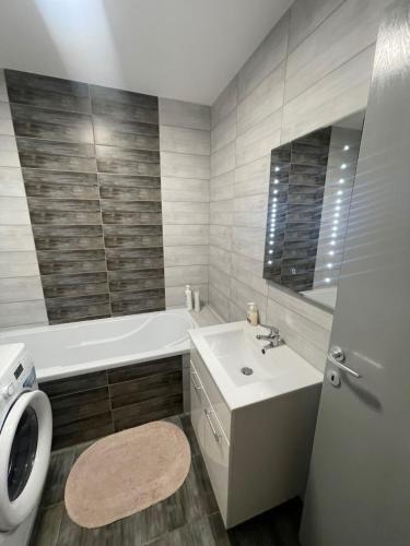 a bathroom with a sink and a tub and a toilet at Coresi Mall Relax apartment in Braşov