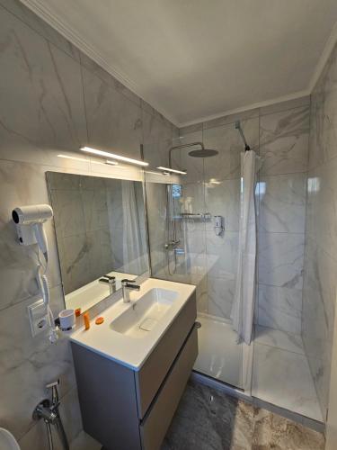 a white bathroom with a sink and a shower at Valpino 