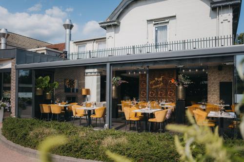 a restaurant with tables and chairs on a patio at Hotel Schimmel in Woudenberg