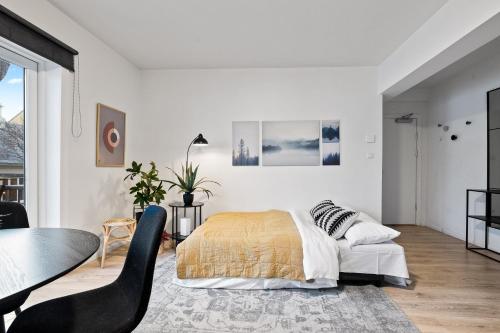 a bedroom with a bed and a table and a chair at Venture Vacation - Cozy and Central Apartment in Reykjavík