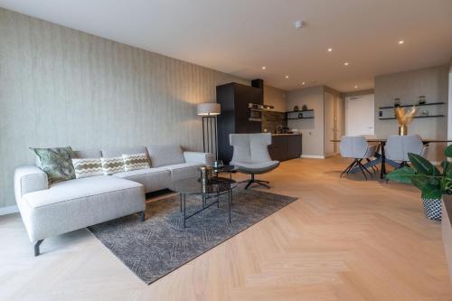 ein Wohnzimmer mit einem Sofa und einem Tisch in der Unterkunft Residentie de Schelde - Apartments with hotel service and wellness in Cadzand-Bad