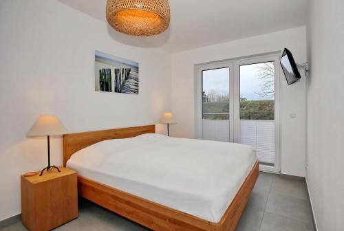 ein Schlafzimmer mit einem großen Bett und einem Fenster in der Unterkunft Strandresidenz Dünenperle Wohnung 9 in Kühlungsborn