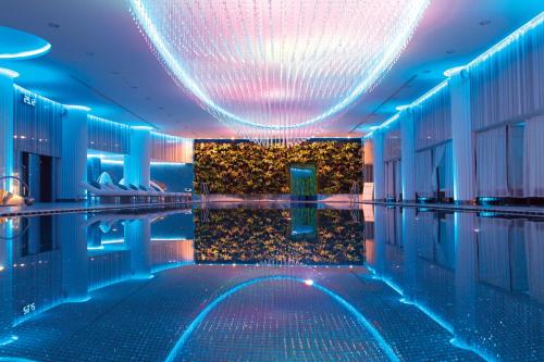 una piscina en un hotel con iluminación azul y púrpura en Tsarsky Hotel en Kiev