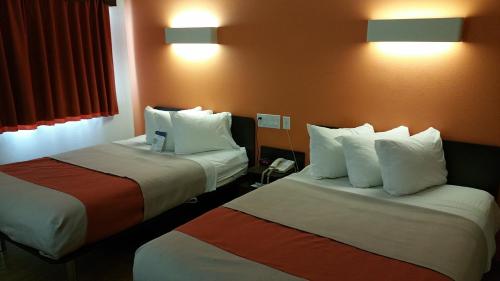 a hotel room with two beds with white pillows at Motel 6-Eagle Pass, TX - Lakeside in Eagle Pass