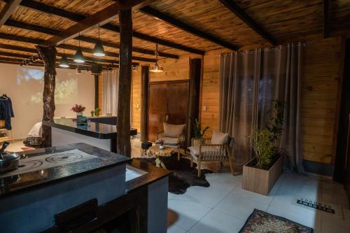 a room with a kitchen and a living room at Cabana com Ofurô e Cinema a 6km do Centro in Ibicaré