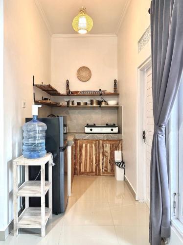 Il comprend une cuisine équipée d'un réfrigérateur et d'un tabouret avec une bouteille d'eau. dans l'établissement Guest house Star No.1, à Bedahulu