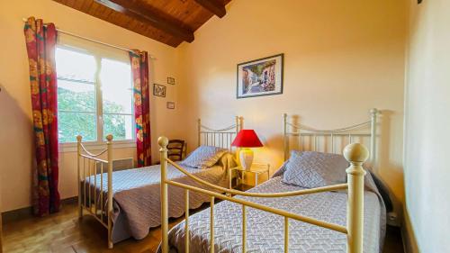 two beds in a bedroom with a window at Villa au calme à proximité de la mer in La Couarde-sur-Mer