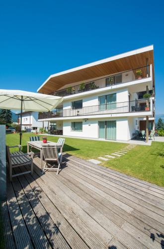 a deck with a table and chairs and a building at Apartment Edelweiss in Brunico