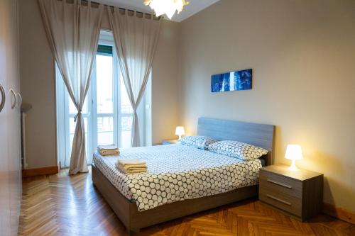 Un dormitorio con una cama y una ventana grande. en Ponte Mosca Apartments, en Turín