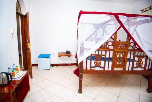 a bed with a canopy in a room at La Neisha Hotel Zanzibar in Stone Town