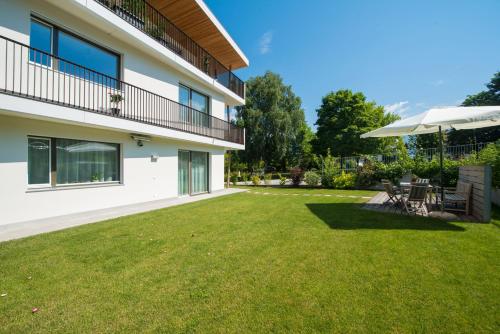 a large yard with chairs and an umbrella at Apartment Edelweiss in Brunico
