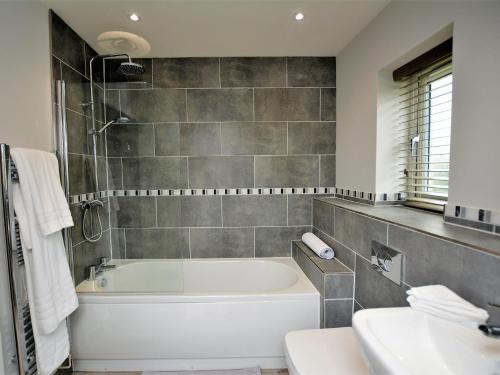 uma casa de banho com uma banheira branca e um lavatório. em 4 bed in Oswestry 74982 em Kinnerley
