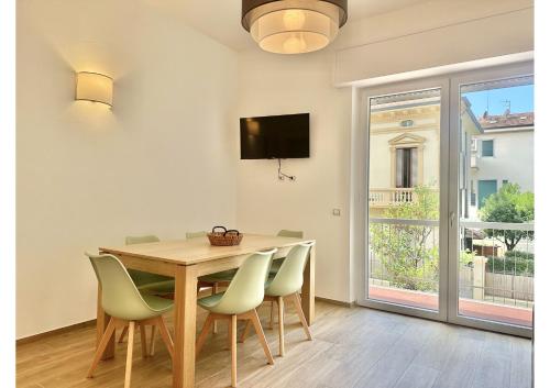 een eetkamer met een tafel en stoelen en een raam bij (3 suites in the sea) luxe apartment in Camaiore