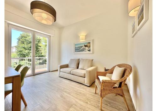 een woonkamer met een bank, stoelen en een tafel bij (3 suites in the sea) luxe apartment in Camaiore