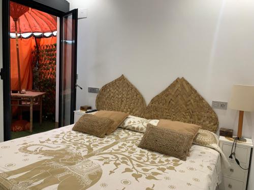 un letto con due cuscini sopra di Apartamento NEPTUNO con piscina a 50 mt de la playa a El Morche