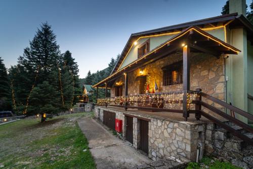 a house with lights on the side of it at Dandy Villas Elatodasos - Chalet Artemis - Fir Forest - Jeep & Nature Lovers in Eptalofos