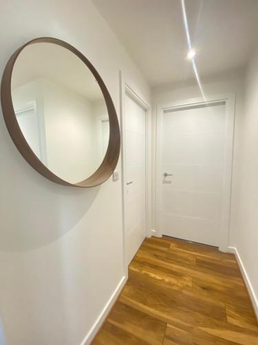 einen Flur mit rundem Spiegel an der Wand in der Unterkunft Modern Double Room in Manchester