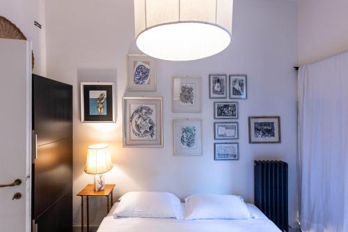 a bedroom with a bed and pictures on the wall at Santa Croce Comfort Apartment in Florence