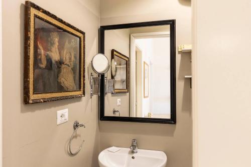 a bathroom with a sink and a mirror at Santa Croce Comfort Apartment in Florence
