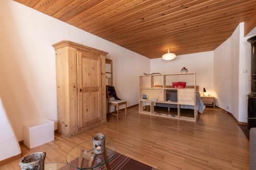 a living room with a desk and a wooden ceiling at Chasa Curasch in Scuol