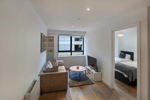 Sala de estar con cama, sofá y mesa en Lovely Spacious Central Croydon Apartment, en Croydon