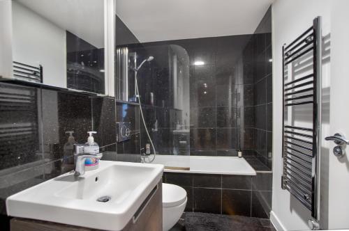 a bathroom with a sink and a toilet at Lovely Spacious Central Croydon Apartment in Croydon