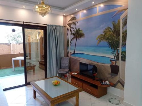 a living room with a desk and a painting on the wall at Comfort Zone at Turtles Beach Resort in Hurghada