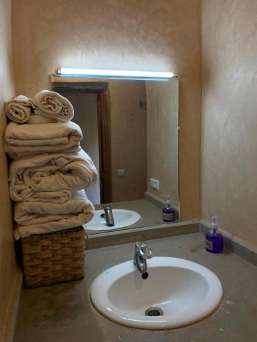 baño con lavabo y una pila de toallas en Panorama Complex en Tahannout