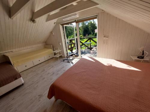 - une chambre avec un lit et une vue sur une terrasse dans l'établissement Plieņciems Urgas apartamenti 2. stāvā, à Plieņciems