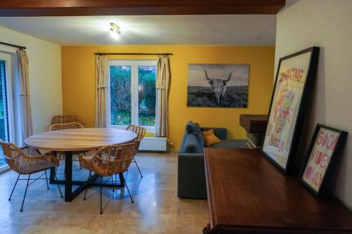 ein Wohnzimmer mit einem Tisch, Stühlen und einem Sofa in der Unterkunft Chez Joséphine in Huy