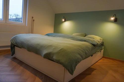 1 cama en un dormitorio con 2 luces en la pared en Chez Joséphine, en Huy